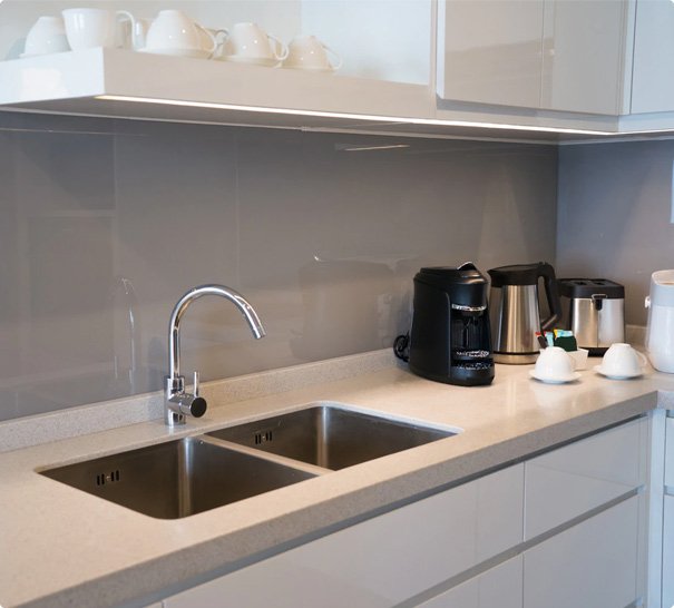 Modern kitchen interior with double sink, chrome faucet, and coffee appliances on countertop